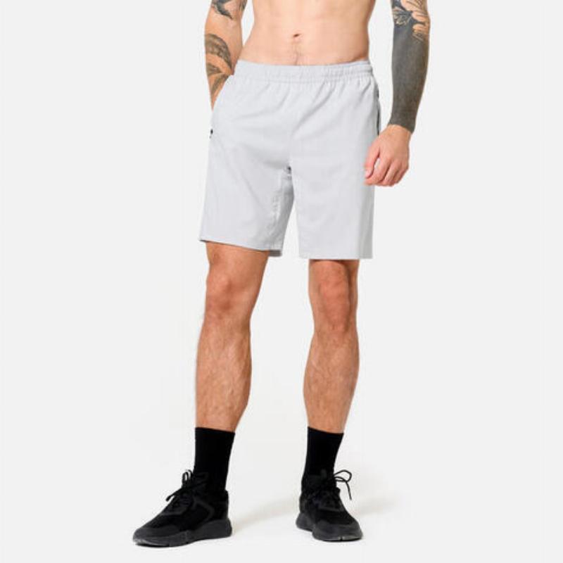 Một thanh niên mặc quần áo tập gym nam cao cấp, chất liệu co giãn và thoáng khí, đang thực hiện bài tập với tạ trong phòng gym hiện đại tại Hà Nội